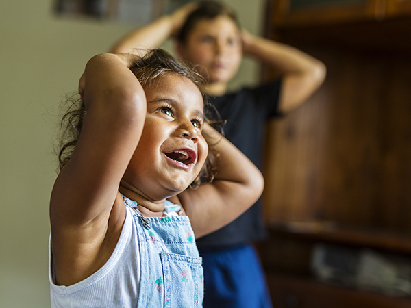 a happy child with her hands on her head