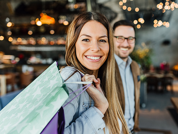women holding a gift bag smiling looking at the camera