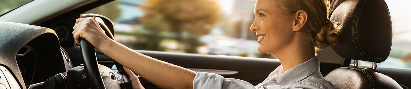 Women smiling driving her car