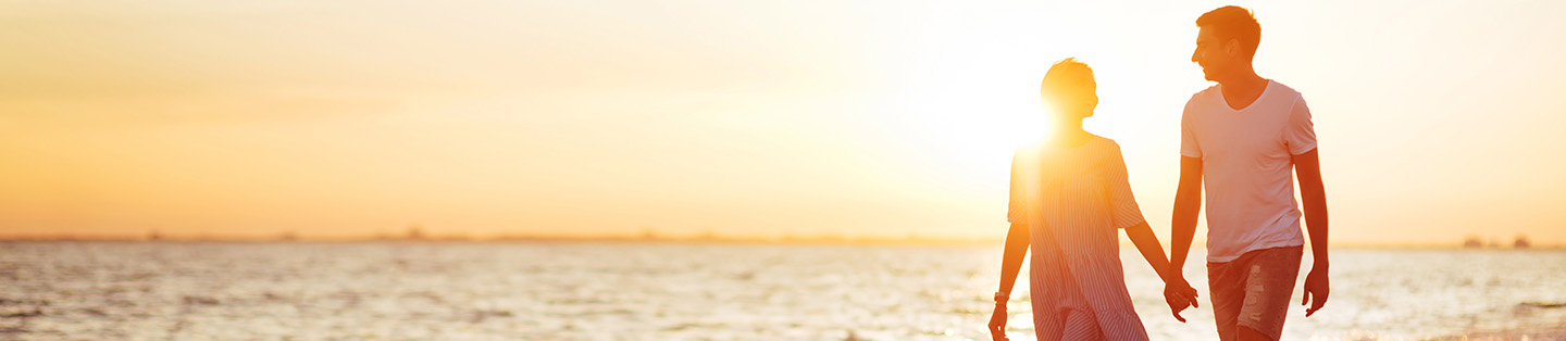 A couple walking on the beach  during a sunset