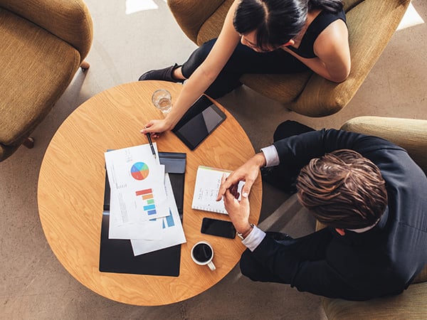 Women and man having a business meeting, looking at graphs